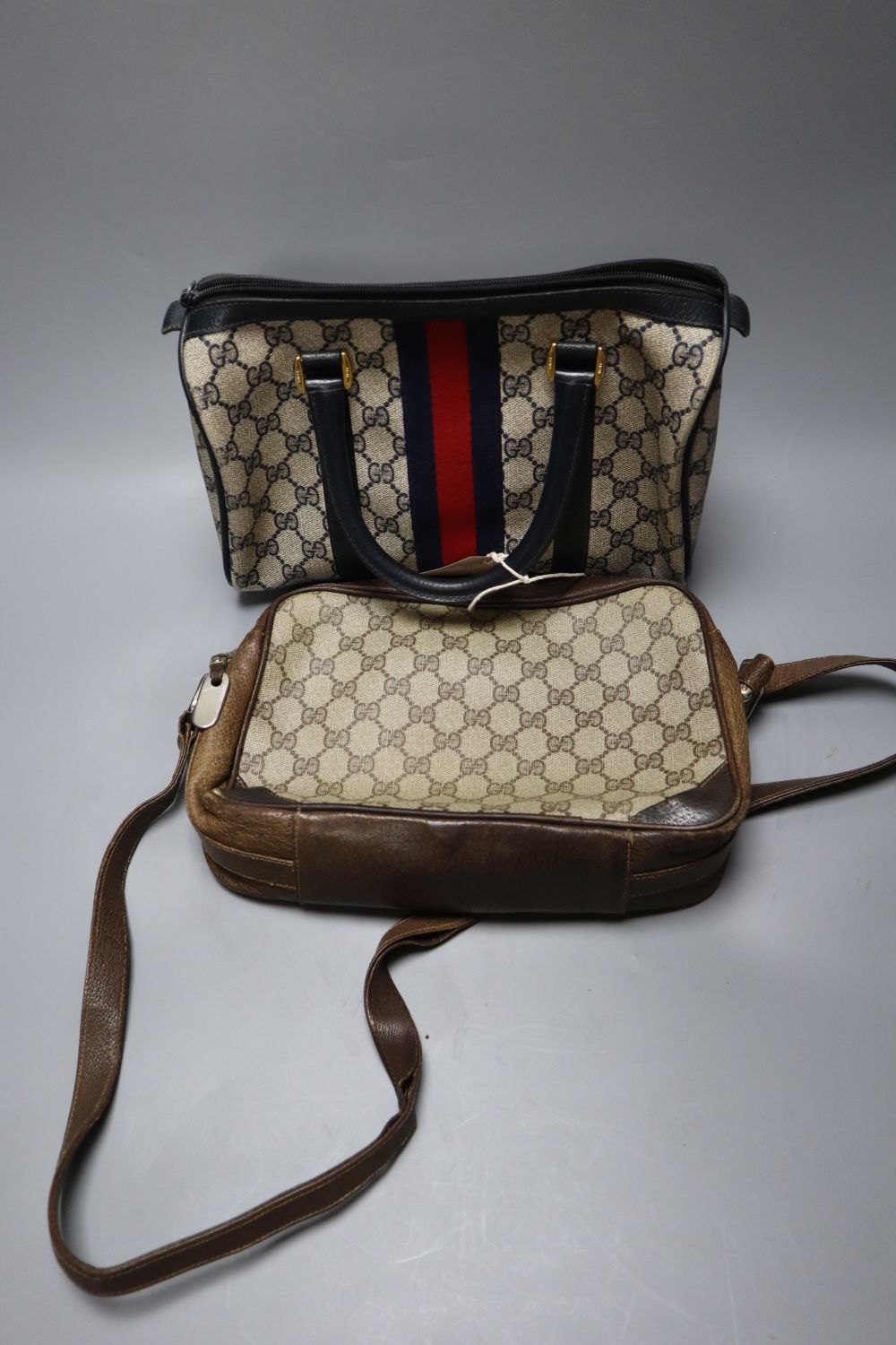 A Gucci handbag, in red holder, and one other Gucci bag